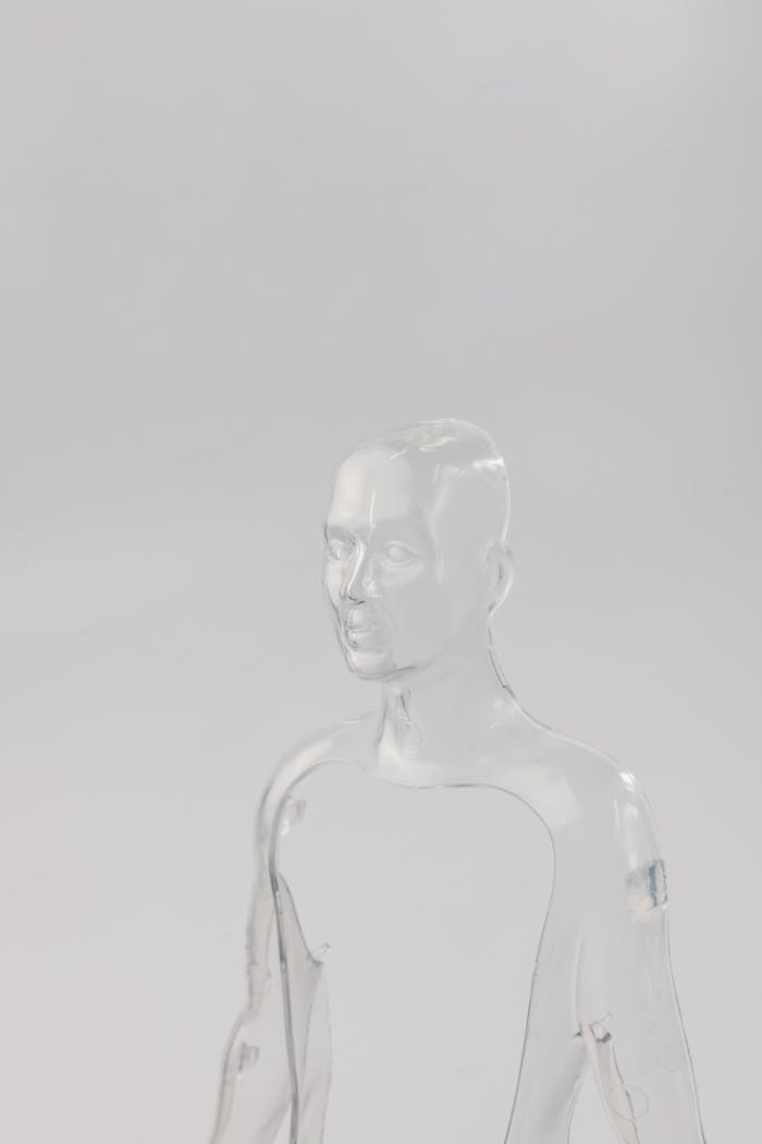 Glass-like transparent mannequin against a light backdrop, showcasing modern minimalism.